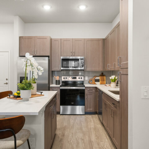 kitchen with modern appliances and island with seating for three at Sanctuary at Daytona